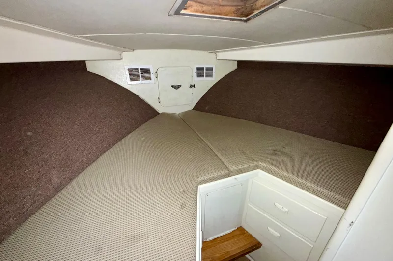 Slide: The Image of 1979 Bertram 35 Flybridge cabin interior with cushioned berth and storage drawers. - 36