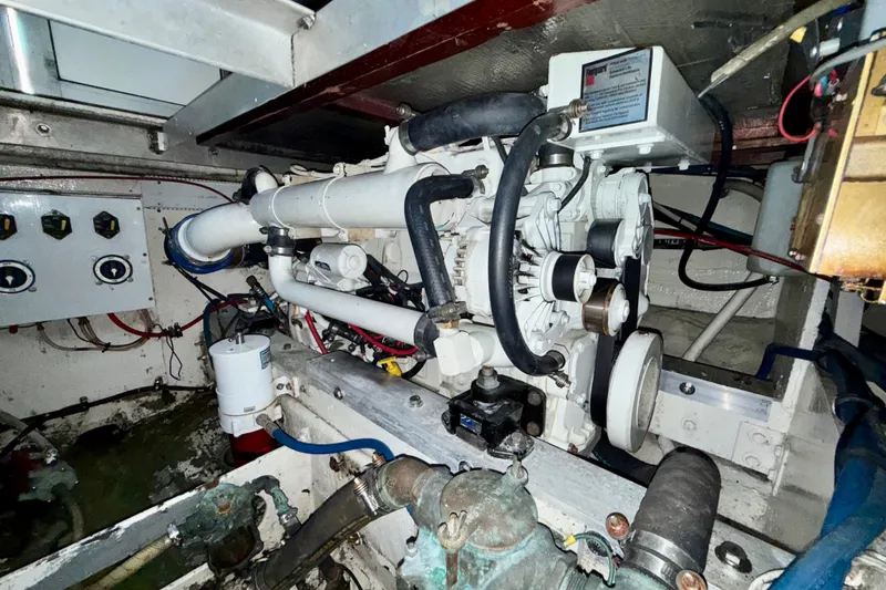 Slide: The Image of Engine room of a 1979 Bertram 35 Flybridge, showcasing mechanical components and wiring. - 42