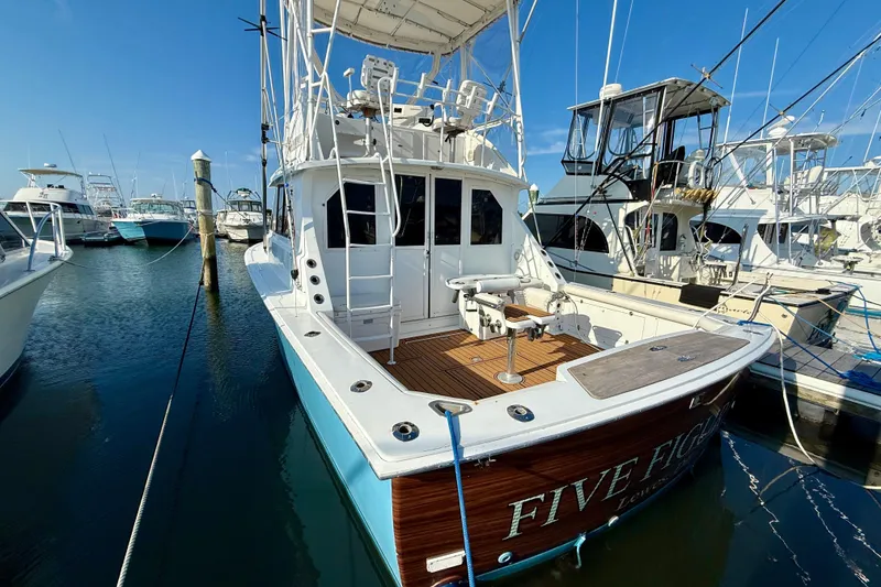 Slide: The Image of 1979 Bertram 35 Flybridge yacht docked at marina under clear blue sky. - 5