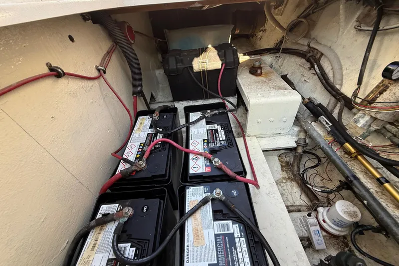 Slide: The Image of Battery compartment of a 1979 Bertram 35 Flybridge boat, showing multiple connected batteries. - 50