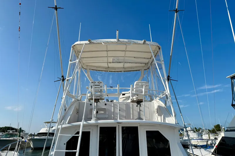Slide: The Image of 1979 Bertram 35 Flybridge yacht with clear blue sky background at marina. - 6