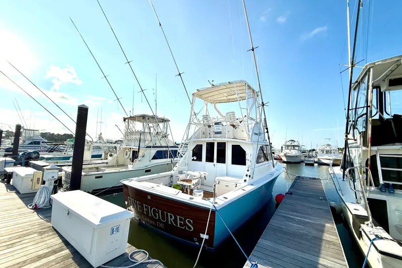 Slide: The Image of 1979 Bertram 35 Flybridge docked at marina under clear blue sky. - 7