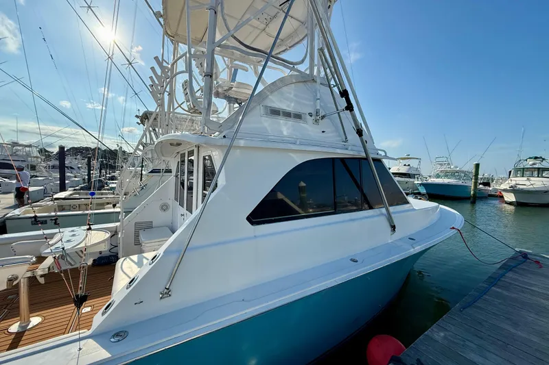 Slide: The Image of 1979 Bertram 35 Flybridge yacht docked at marina under clear blue sky. - 8