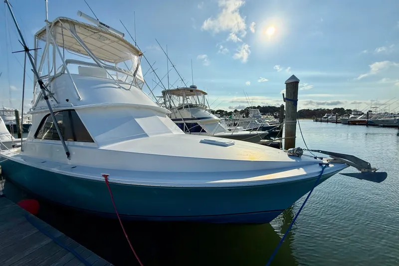 Slide: The Image of 1979 Bertram 35 Flybridge yacht docked in a sunny marina. - 9