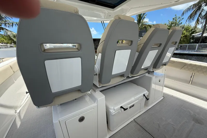 Slide: The Image of 2022 Regal 38 SAV boat interior with seating and storage, featuring a Yeti cooler. - 16