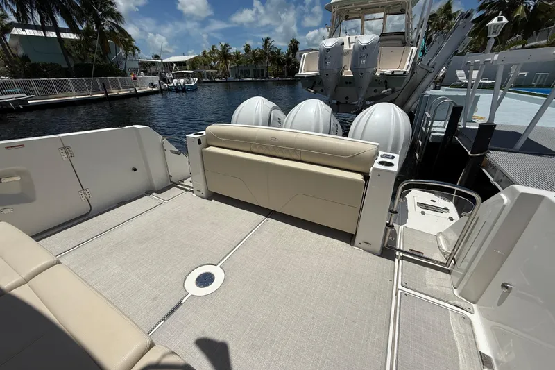Slide: The Image of 2022 Regal 38 SAV boat deck with seating, docked by a waterfront. - 18