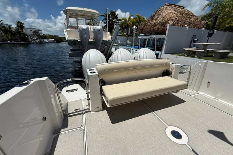 Slide: The Image of 2022 Regal 38 SAV boat with seating and powerful outboard engines docked by the water. - 20