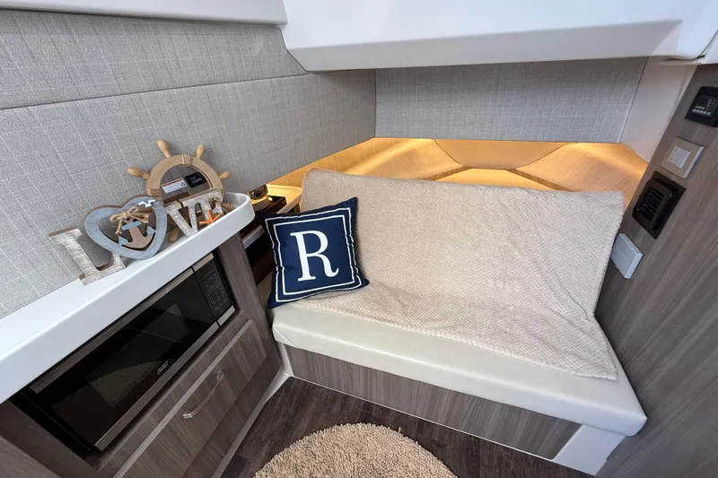 Slide: The Image of 2022 Regal 38 SAV interior with cozy seating, decorative pillow, and nautical decor. - 25