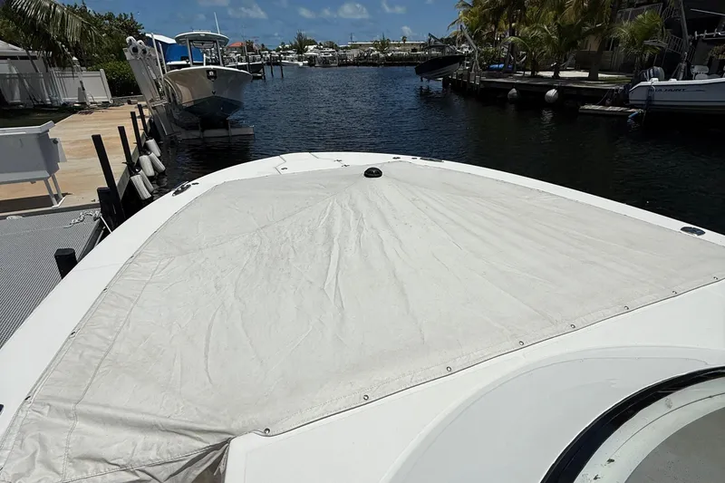 Slide: The Image of 2022 Regal 38 SAV boat with covered bow, docked in a marina. - 38