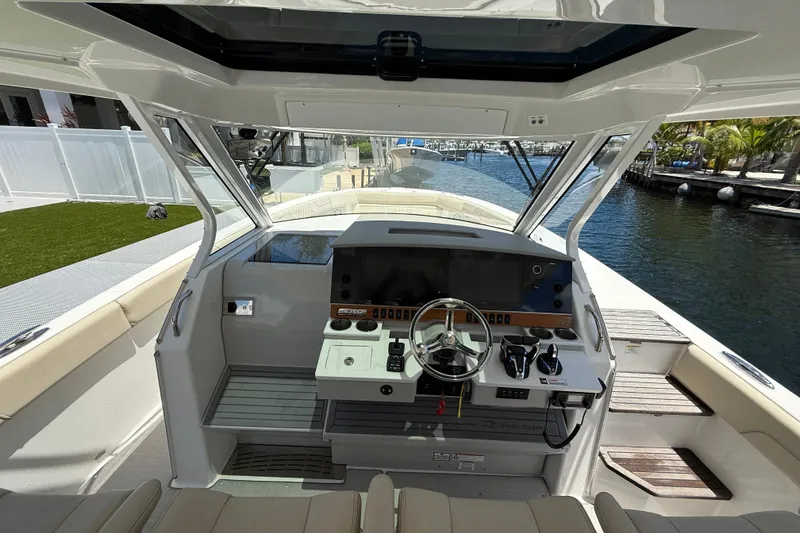 Slide: The Image of 2022 Regal 38 SAV boat cockpit with modern controls and waterfront view. - 4