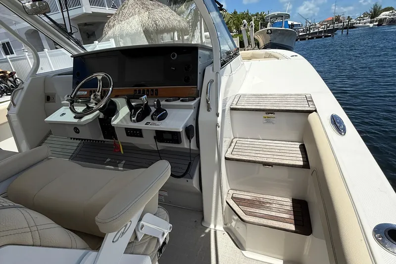 Slide: The Image of 2022 Regal 38 SAV boat cockpit with helm, controls, and steps leading to deck. - 5