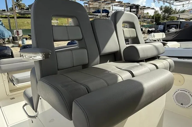 Slide: The Image of 2023 Boston Whaler 330 Outrage boat seats, featuring luxurious gray upholstery and armrests. - 10