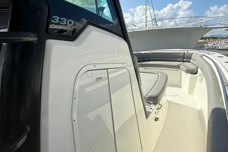 Slide: The Image of 2023 Boston Whaler 330 Outrage boat with spacious seating and sleek design. - 11
