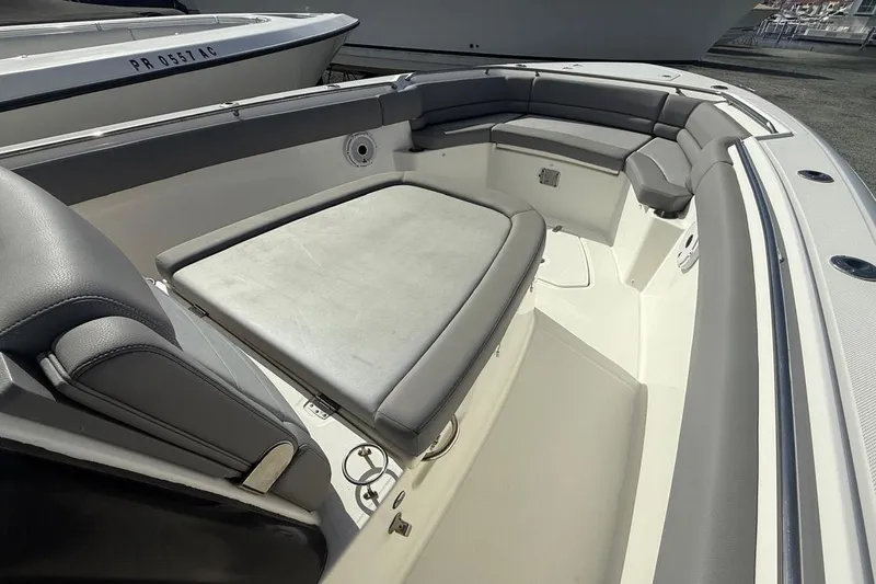 Slide: The Image of 2023 Boston Whaler 330 Outrage boat interior with cushioned seating and sleek design. - 12