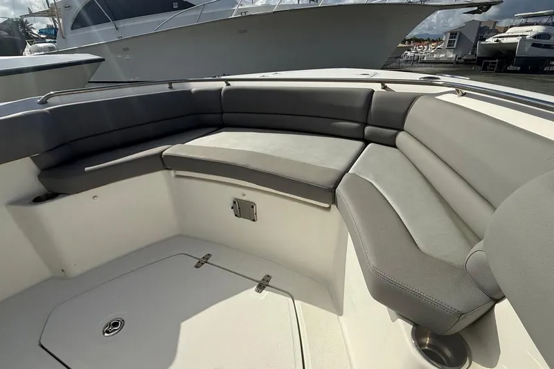 Slide: The Image of 2023 Boston Whaler 330 Outrage boat interior with cushioned seating area. - 13