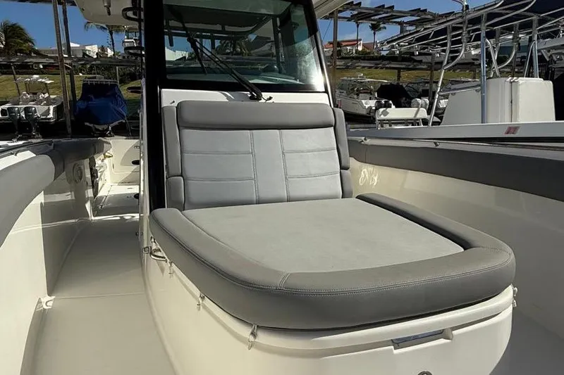 Slide: The Image of 2023 Boston Whaler 330 Outrage boat interior with cushioned seating area. - 14