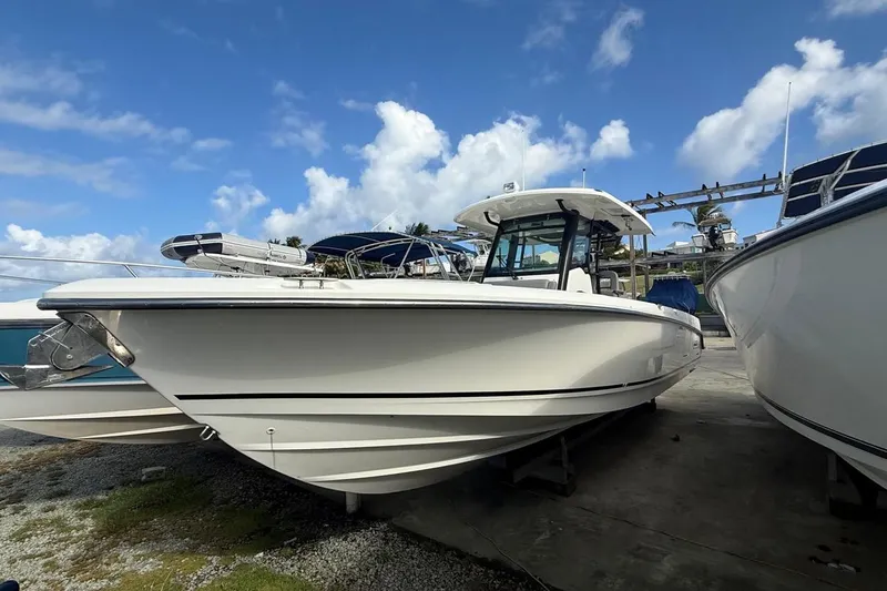 Slide: The Image of 2023 Boston Whaler 330 Outrage boat docked under a clear blue sky. - 4