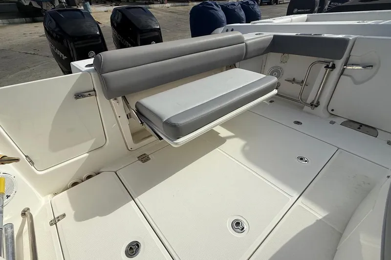 Slide: The Image of 2023 Boston Whaler 330 Outrage boat interior with foldable seating and Mercury engines. - 5