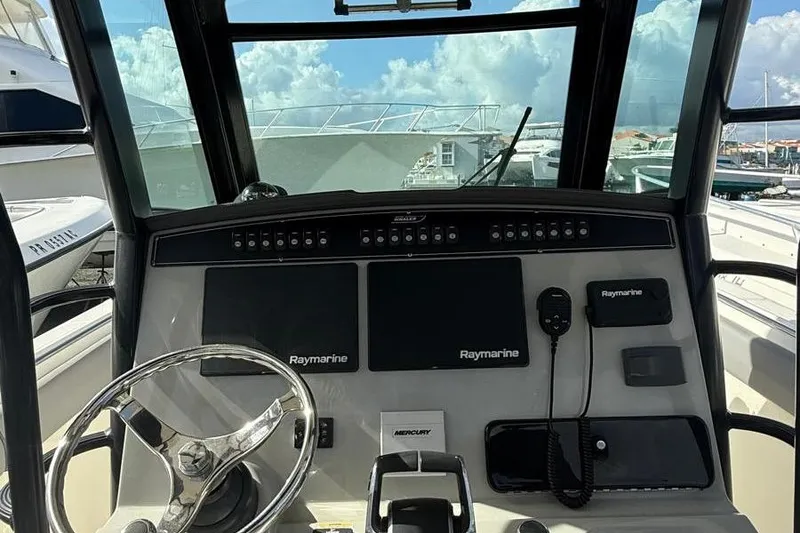 Slide: The Image of 2023 Boston Whaler 330 Outrage helm with Raymarine electronics and Mercury controls. - 8