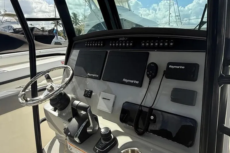 Slide: The Image of 2023 Boston Whaler 330 Outrage helm with Raymarine electronics and steering wheel. - 9