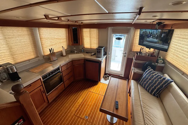 Slide: The Image of Interior of 2005 Nordic Tug 37 Flybridge with kitchen, seating, and TV. - 23