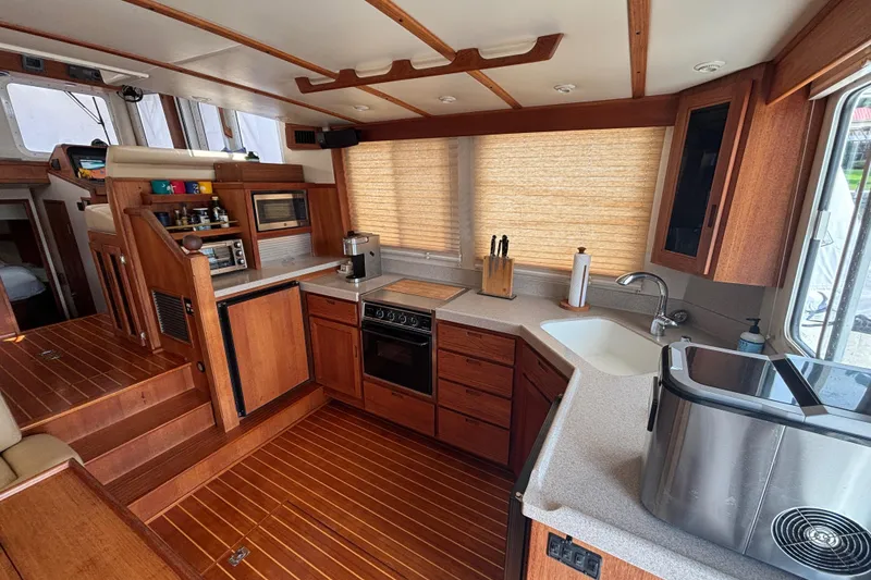 Slide: The Image of Interior of 2005 Nordic Tug 37 Flybridge with wooden cabinetry and modern kitchen amenities. - 25