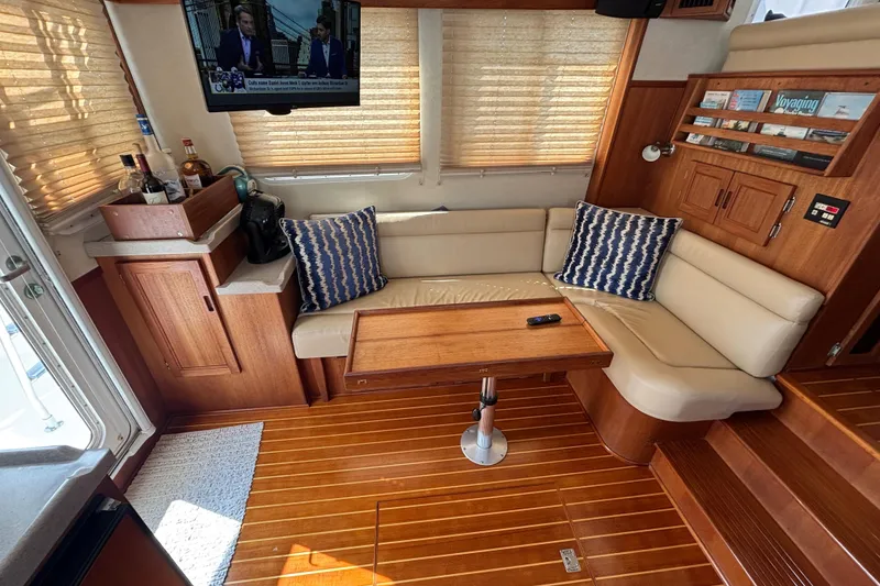 Slide: The Image of Interior of 2005 Nordic Tug 37 Flybridge with cozy seating and wooden accents. - 26