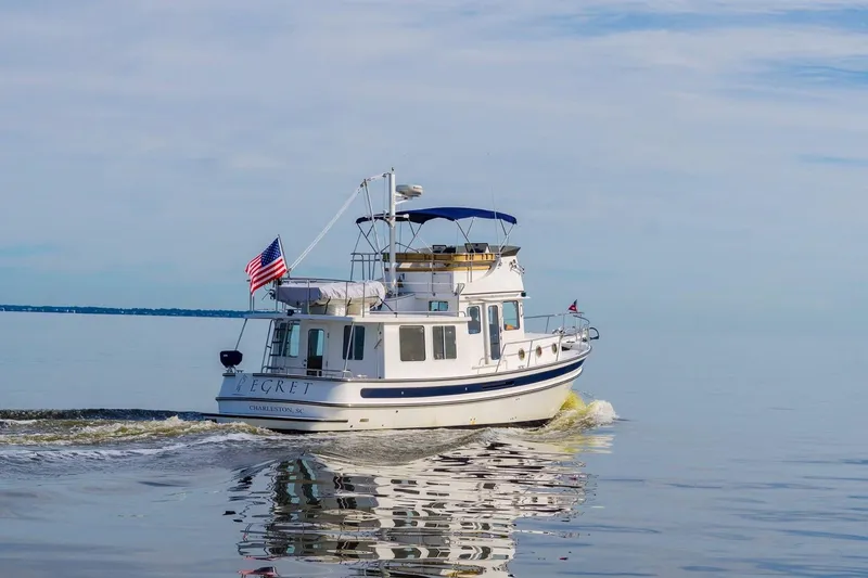 Slide: The Image of 2005 Nordic Tug 37 Flybridge cruising on calm waters with American flag. - 3
