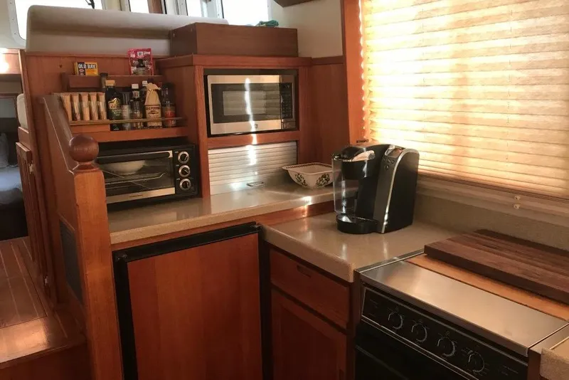 Slide: The Image of Cozy kitchen in 2005 Nordic Tug 37 Flybridge with appliances and wooden cabinetry. - 31