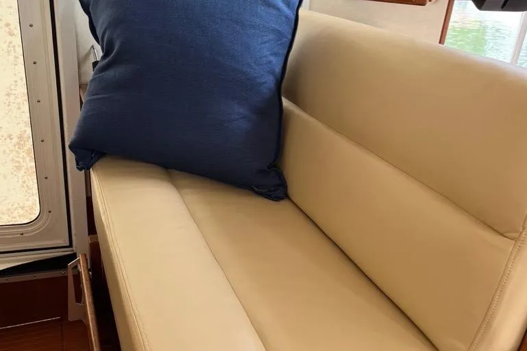 Slide: The Image of Helm Seat on Starboard Side in Pilothouse featuring Beige Ultraleather seating with blue cushion on 2005 Nordic Tug 37 Flybridge. - 36
