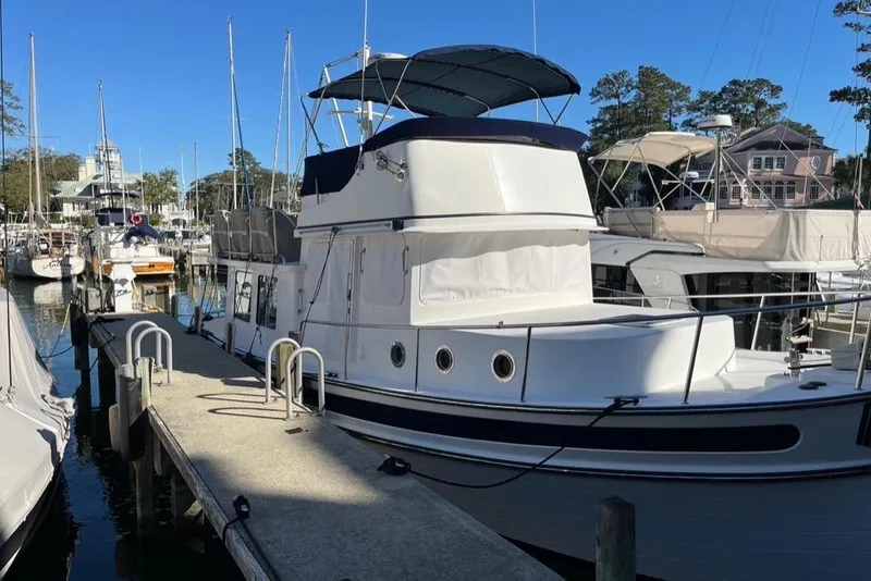 Slide: The Image of 2005 Nordic Tug 37 Flybridge docked at marina under clear blue sky. - 4