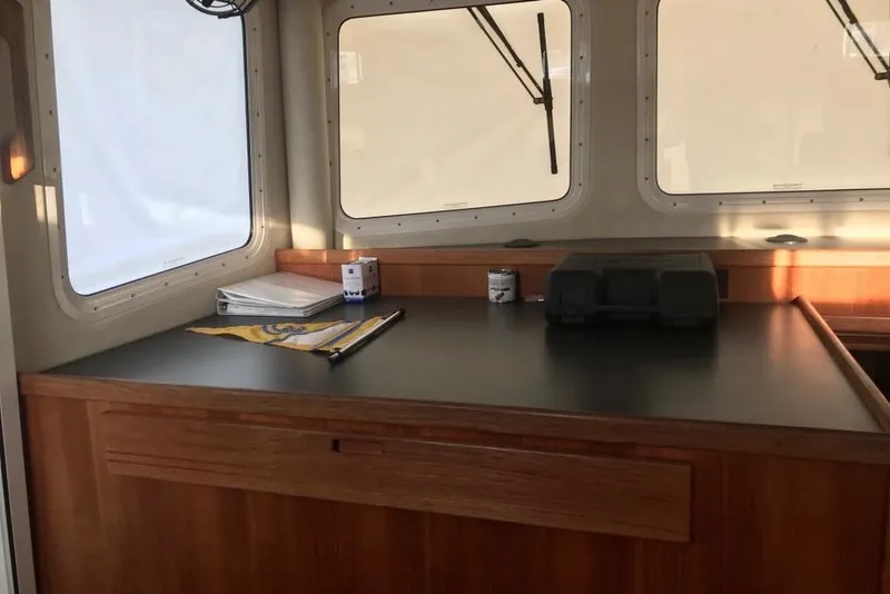 Slide: The Image of Pilothouse of 2005 Nordic Tug 37 Flybridge with wooden cabinetry and large windows. - 42