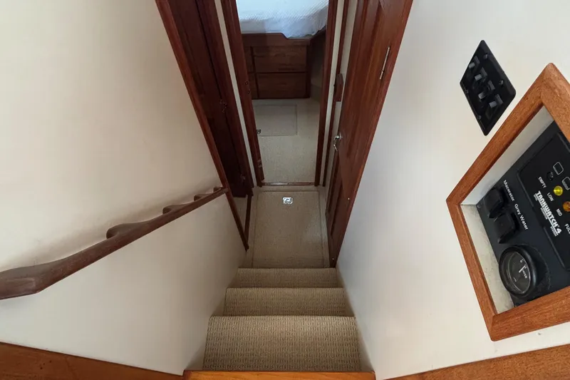 Slide: The Image of Stairway inside 2005 Nordic Tug 37 Flybridge, featuring wooden handrails and control panel. - 43