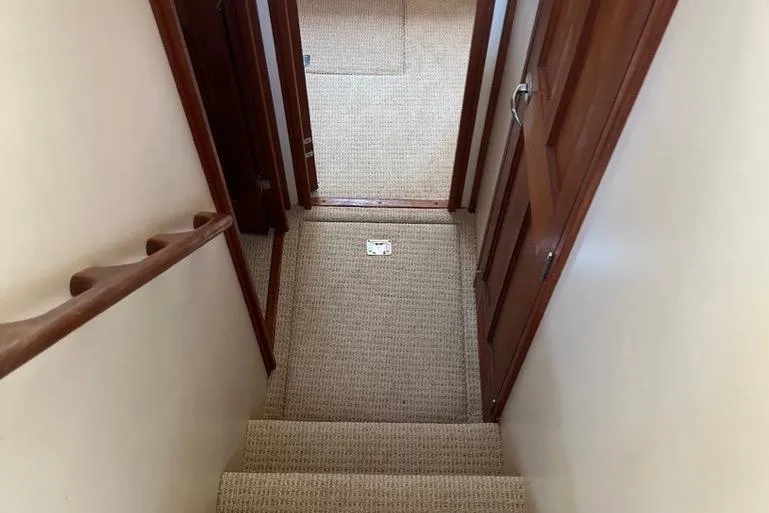 Slide: The Image of Stairway inside 2005 Nordic Tug 37 Flybridge with carpeted steps and wooden handrails. - 44