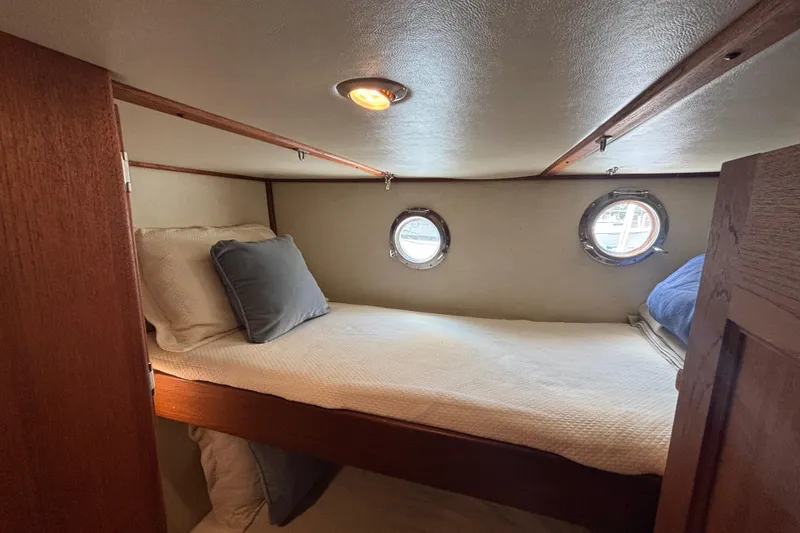 Slide: The Image of Cozy cabin interior of 2005 Nordic Tug 37 Flybridge with porthole windows and bedding. - 54
