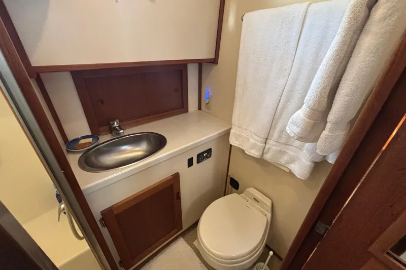 Slide: The Image of 2005 Nordic Tug 37 Flybridge bathroom with sink, toilet, and towels. - 57