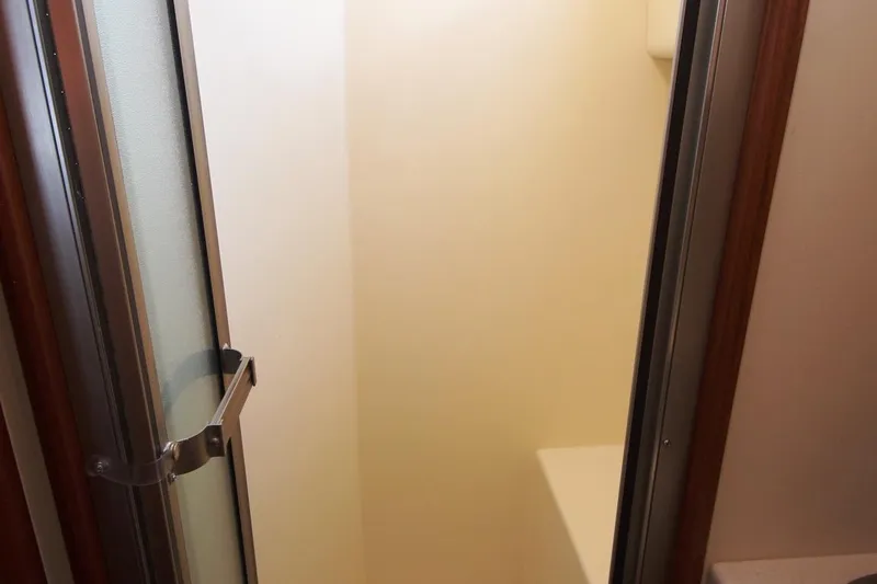 Slide: The Image of Shower area inside 2005 Nordic Tug 37 Flybridge boat, featuring a glass door. - 59