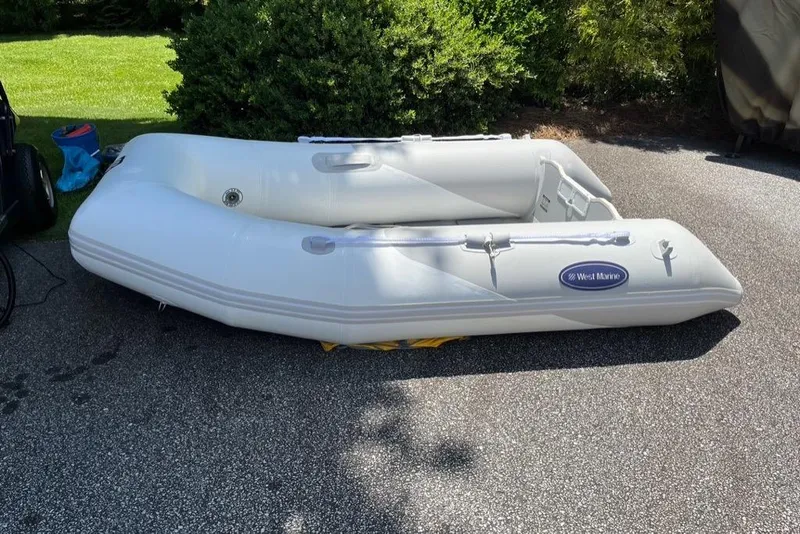 Slide: The Image of Inflatable West Marine dinghy on pavement, surrounded by greenery. Nordic Tug 37 Flybridge, 2005. - 60