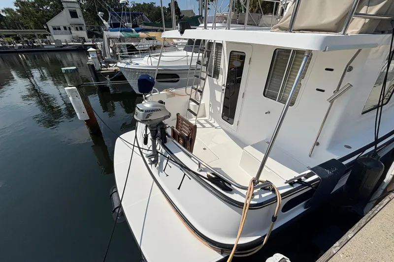 Slide: The Image of Aft Shot of 2005 Nordic Tug 37 Flybridge dockside with dingy motor on bracket - 7