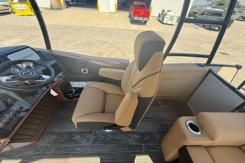 Slide: The Image of 2025 Tahoe Pontoon Cascade Cruise Funship helm with tan seating and modern controls. - 13