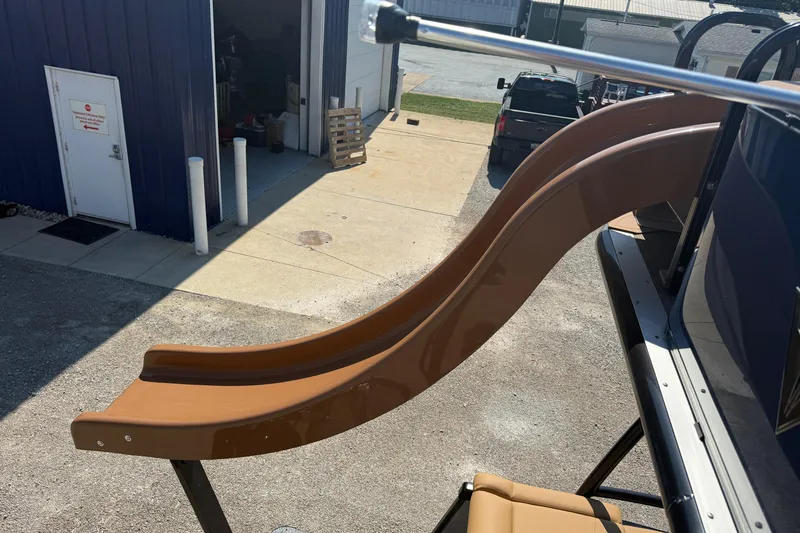 Slide: The Image of 2025 Tahoe Pontoon Cascade Cruise Funship with slide, parked near a blue building. - 9