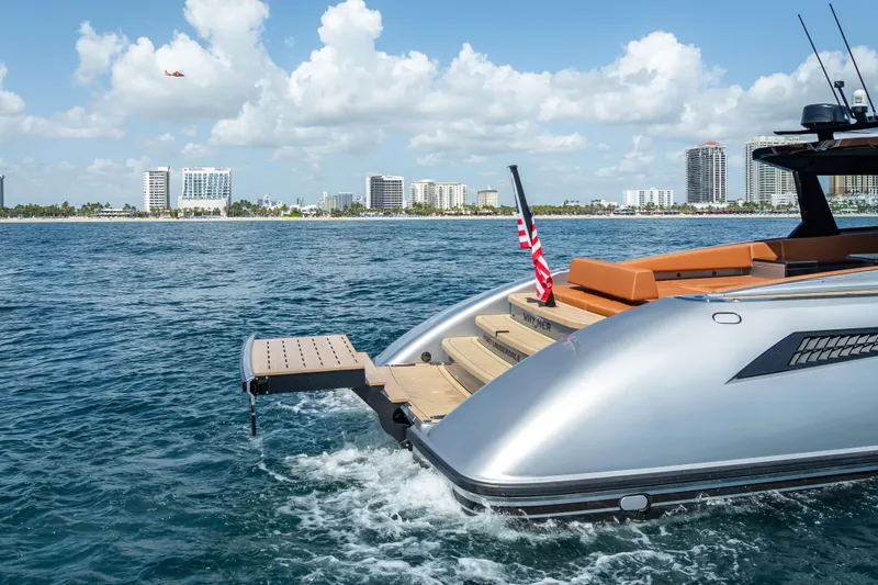 Slide: The Image of 2024 Wajer 55 HT yacht on water, city skyline in background, American flag displayed. - 24
