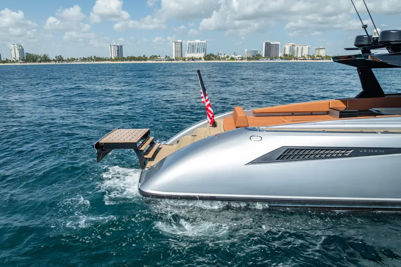 Slide: The Image of 2024 Wajer 55 HT yacht cruising near city skyline, featuring sleek design and American flag. - 25
