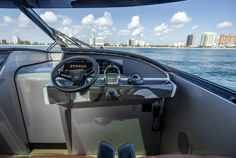 Slide: The Image of Helm of 2024 Wajer 55 HT yacht with modern controls, overlooking ocean and cityscape. - 79