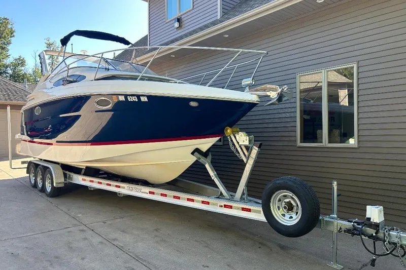 The Image of 2017 Regal 30 Express boat on trailer beside house. - 0