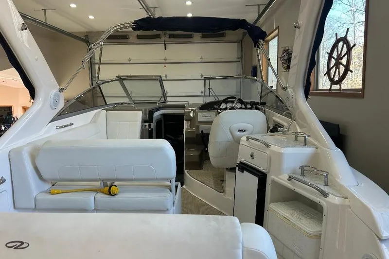 Slide: The Image of 2017 Regal 30 Express boat interior with white seating and helm in a garage. - 10