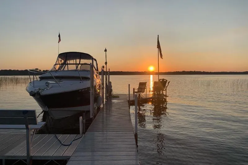 Slide: The Image of 2017 Regal 30 Express boat docked at sunset on a serene lake. - 13