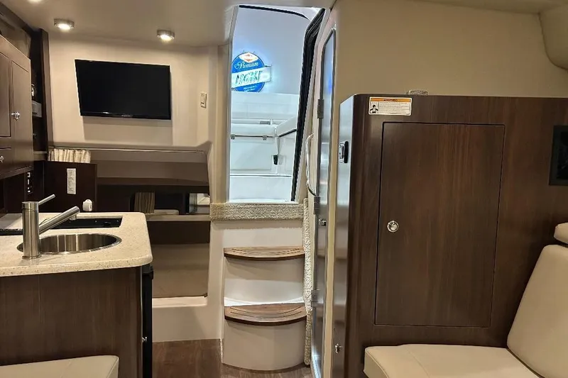 Slide: The Image of Interior of 2017 Regal 30 Express boat with kitchenette, TV, and seating area. - 6