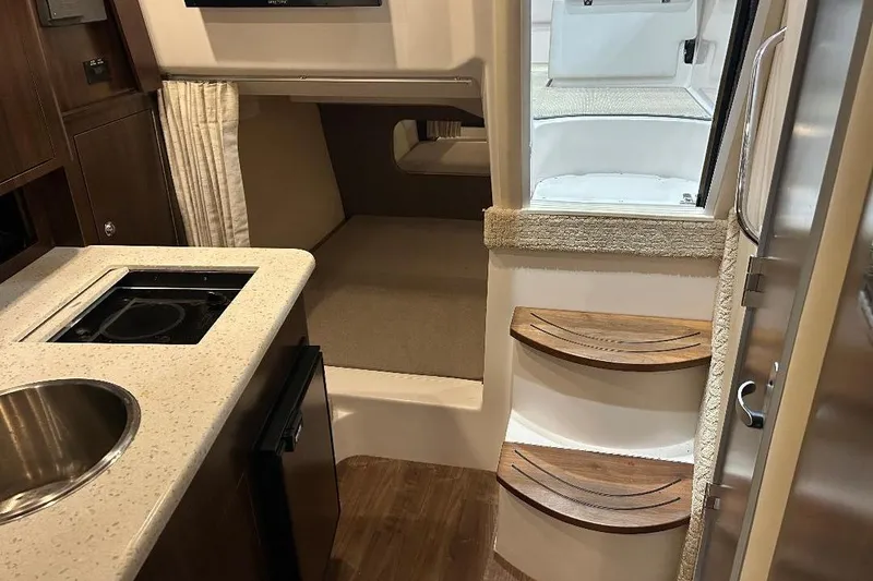 Slide: The Image of 2017 Regal 30 Express interior with kitchenette, steps, and cozy cabin space. - 9