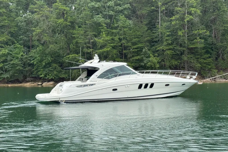 Slide: The Image of 2007 Sea Ray 48 Sundancer yacht cruising on a serene lake with lush forest backdrop. - 13